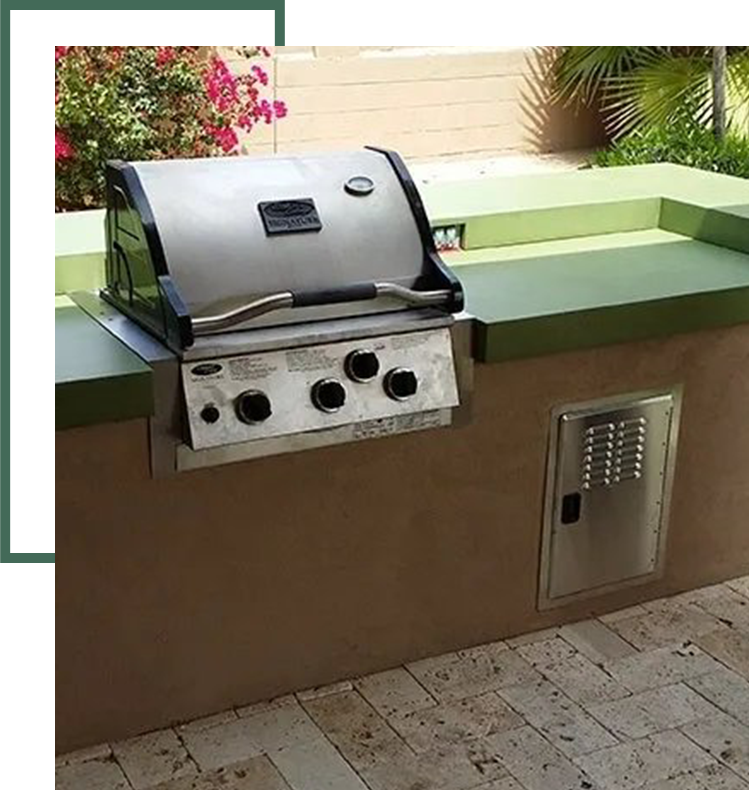 A grill on top of a counter next to flowers.